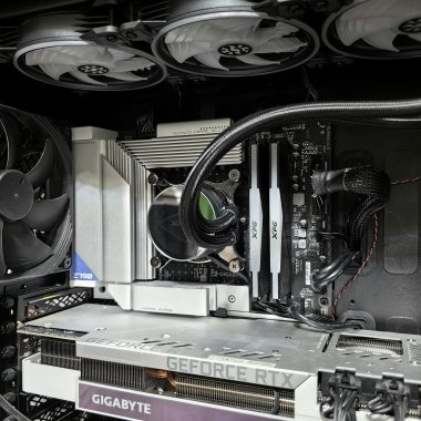 Close-up of a high-performance gaming PC build featuring a Geforce RTX graphics card and complex cooling system.