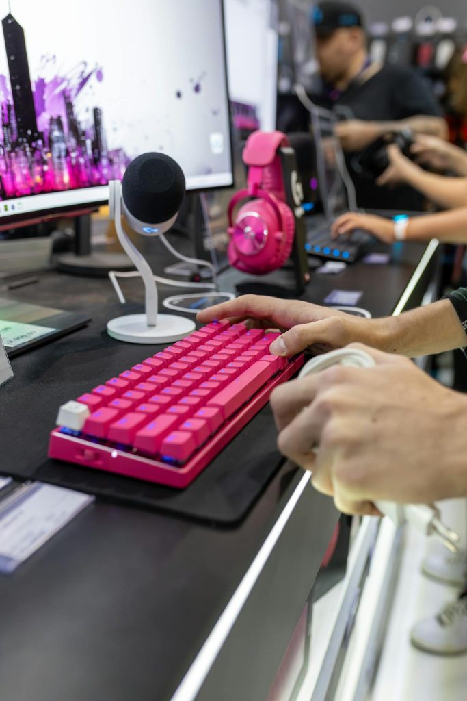 Close-up of a vibrant gaming setup featuring a pink keyboard and headset, ideal for streamers.