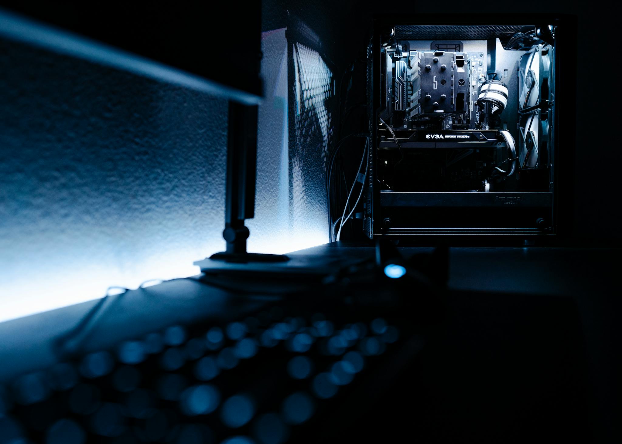 Home Dark, atmospheric shot of a high-end gaming PC setup in a minimalist room.