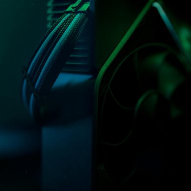 Dark close-up of a gaming PC cooling system with visible wires and fan.